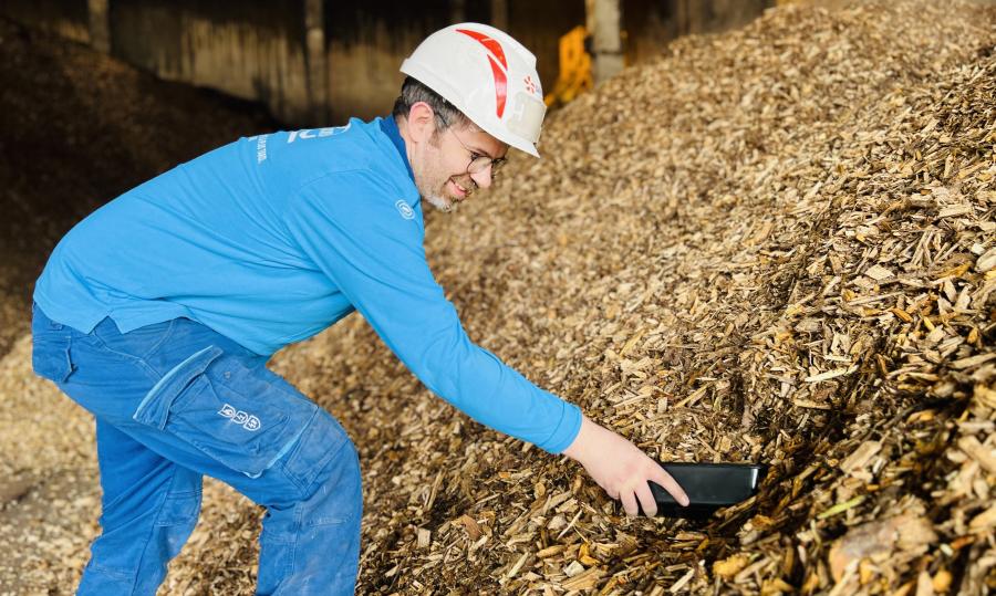 Technicien Dalkia manipulant de la biomasse